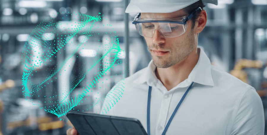 A man with protective glasses in a production factory with tablet in hands