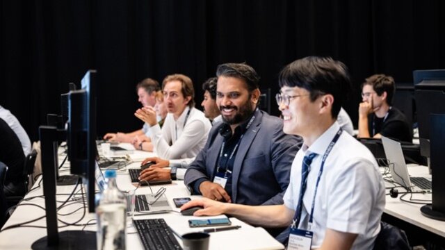 Several individuals sitting in front of their laptops in a tips-and-tricks session at Realize LIVE. 