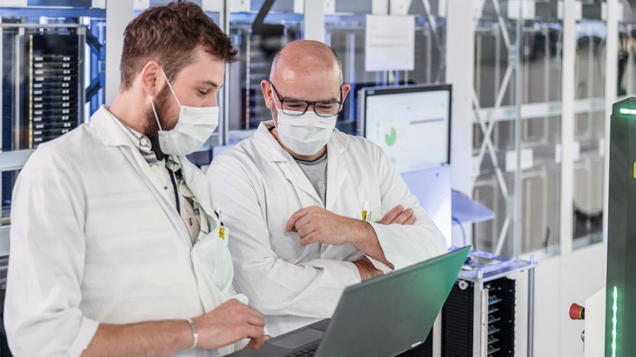 Two engineers on the electronics manufacturing shop floor discussing quoting automated using the BOM connector