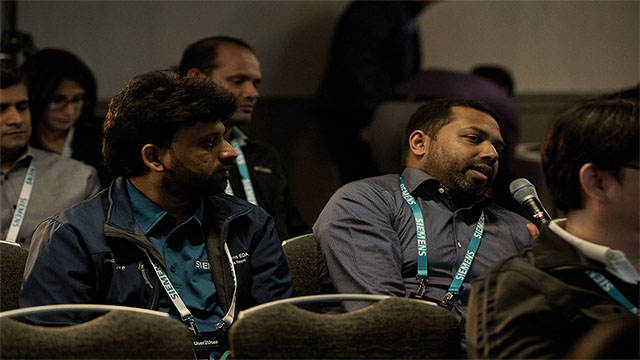 A member of the Siemens User2User conference audience asks a question during a session.