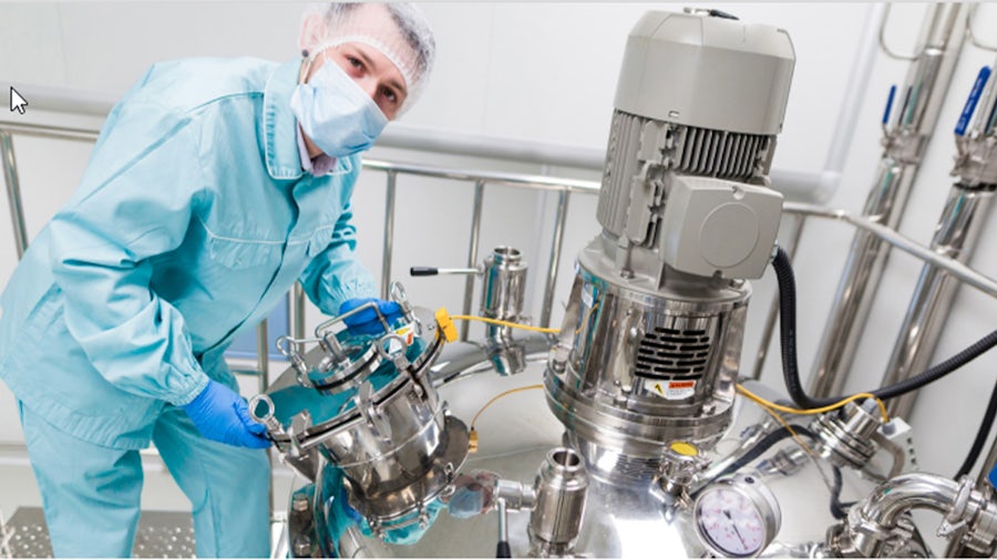 Scientist with pharmaceutical machinery.