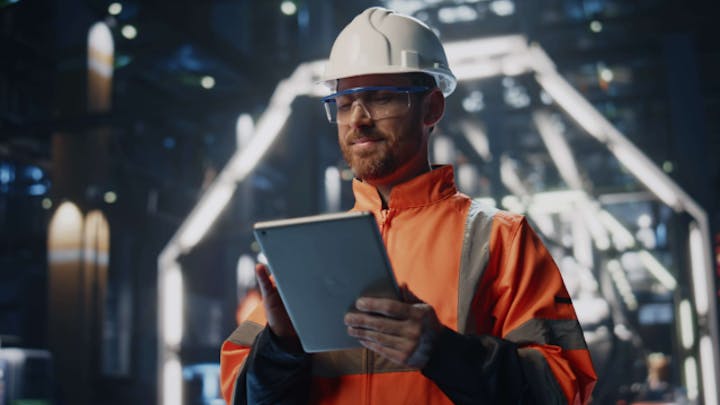 An engineer is looking at an electrical diagram on a tablet screen.