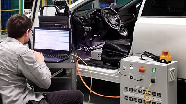 A man works with the Simcenter vehicle energy management (VEM) driving robot.