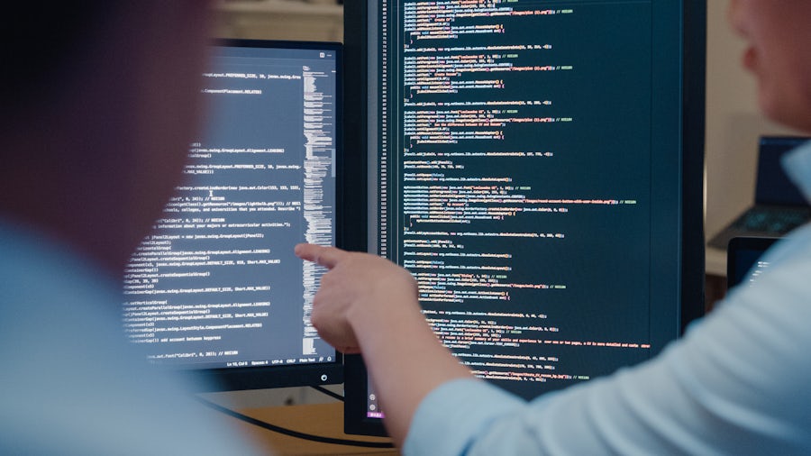 people looking at code on monitors