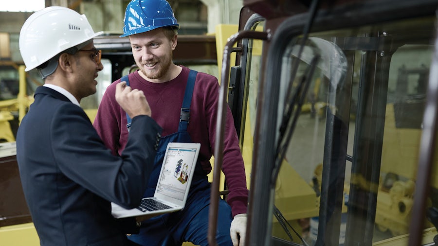 Two men in a heavy equipment manufacturing setting