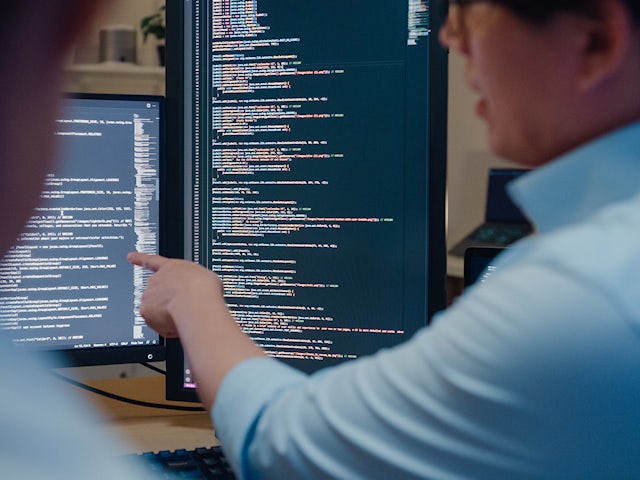 two engineers debugging software code.