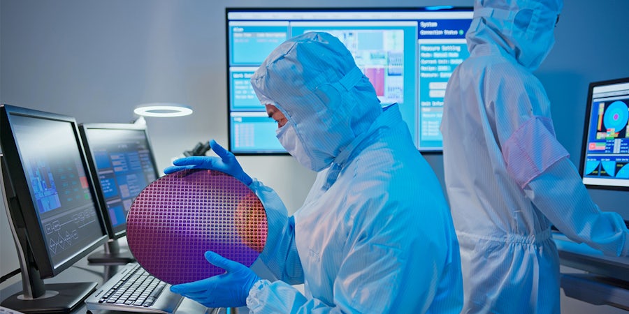 Person looking at wafer in a fabrication lab