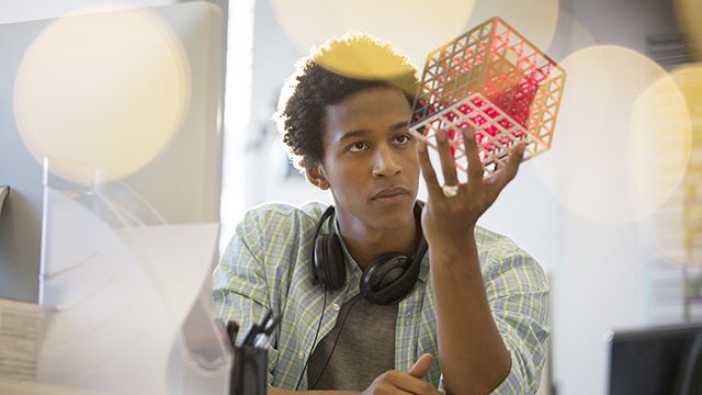 Un estudiante de ingeniería observa y estudia el modelo impreso en 3D de un cuadrado dentro de un rectángulo.