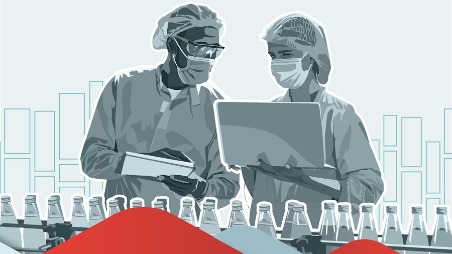 Two manufacturing floor operators check food & beverage machine performance on a laptop computer.