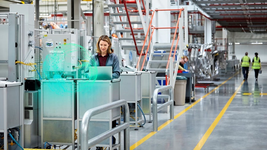 Mitarbeiterin arbeitet am Computer in einer Fertigungsstätte