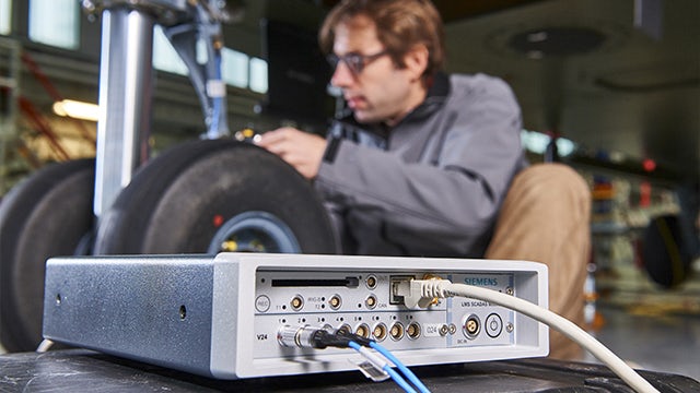Ingenieur bei der Arbeit am Flugzeug mit einem Simcenter SCADAS-Gerät