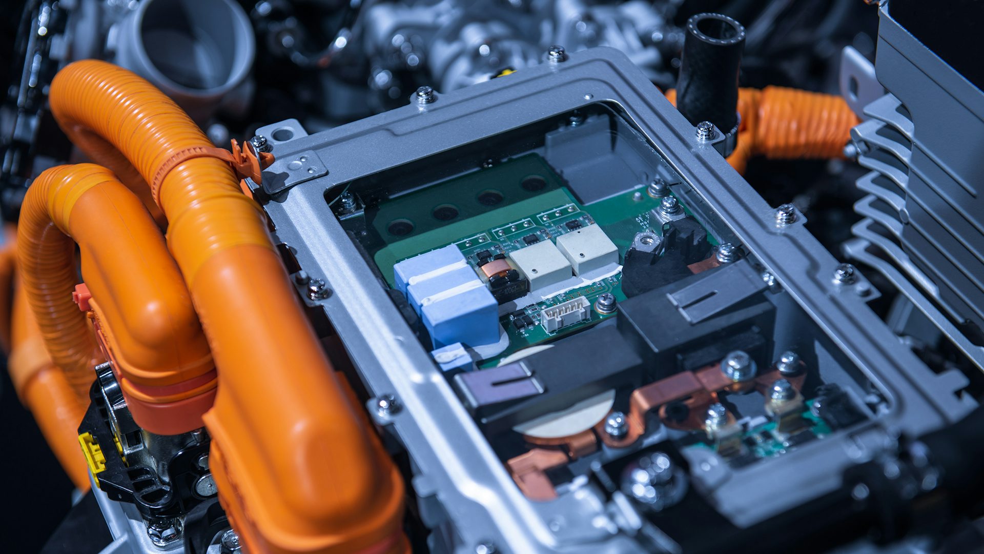 A close-up view of an electronic control box in a factory. The electrical control box has a clear top where you can see into the box where the insides of the computer are visible.