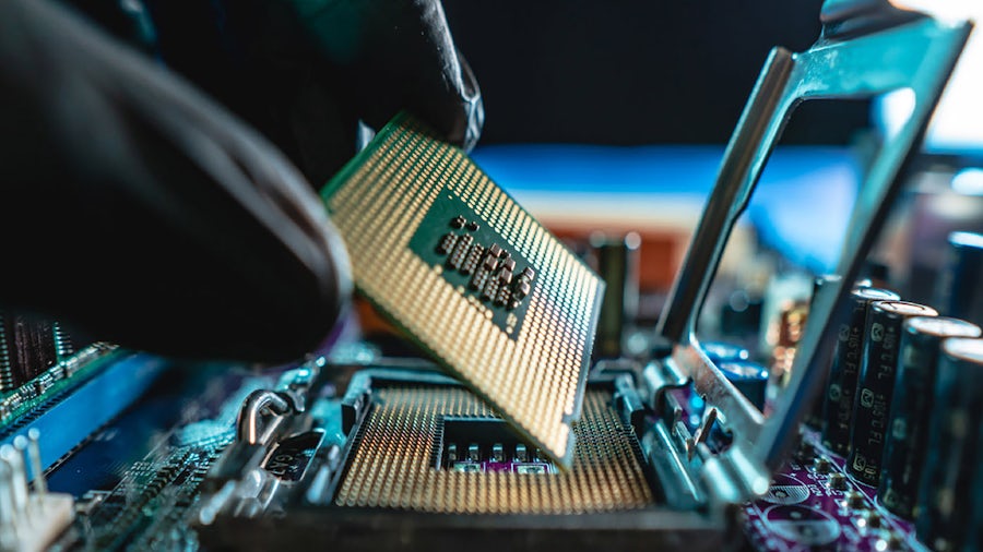 black latex gloved fingers inserting a chip into a chassis