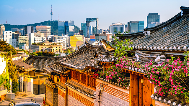 Bukchon Hanok Village with Seoul city skyline in background, South Korea.