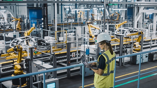An engineer in a factory using Insight Hub solutions and data visualization to monitor machine performance on the line.