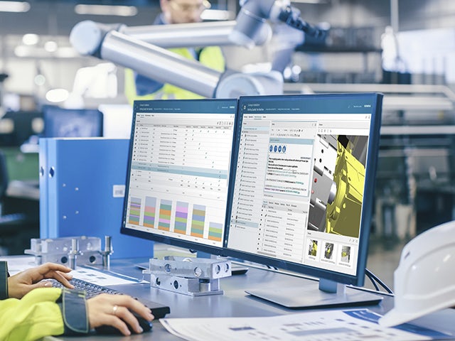 Image of worker reviewing assembly process details in Teamcenter Easy Plan software on a computer screen on the shop floor.