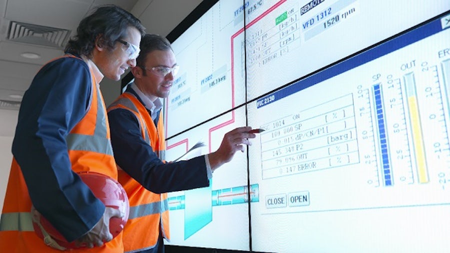 Engineers collaborating in front of large white board