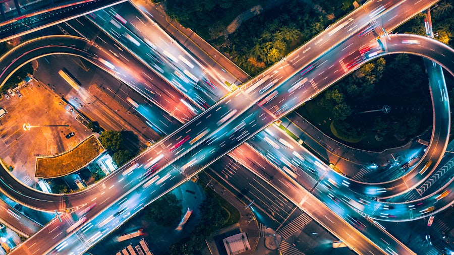 Road junction at night, in the shape of the digital twin symbol