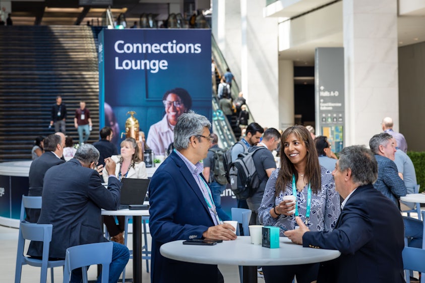 Two conference attendees have a discussion in the Siemens Realize LIVE Connection Lounge.