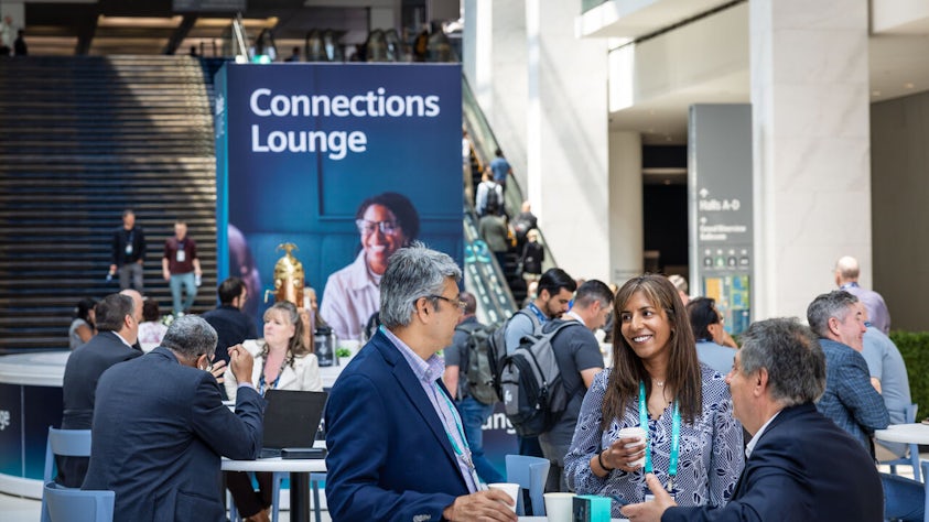 Two conference attendees have a discussion in the Siemens Realize LIVE Connection Lounge.