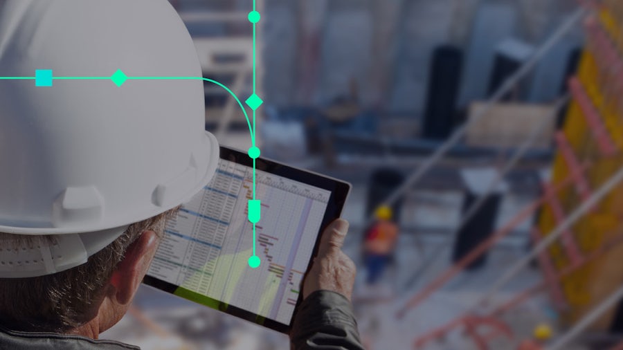 Homme portant des lunettes de sécurité et tenant une tablette dans un environnement industriel