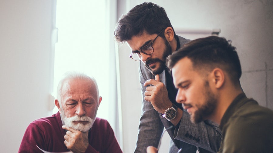 Image of three engineers reading the MBCSE whitepaper by Perti Solanti with interest.