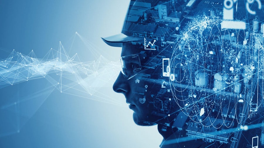 Picture of man wearing hardhat with transparent image of factory satellite image and manufacturing equipment floating overlays, representing smart manufacturing, digital threads, and industry 4.0.