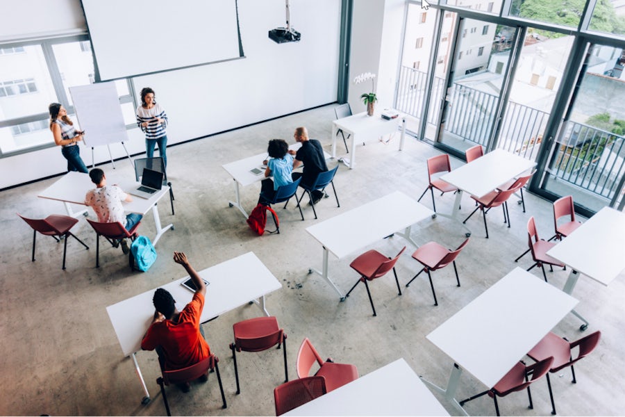 Students engaged in classroom learning with teacher in front of the room