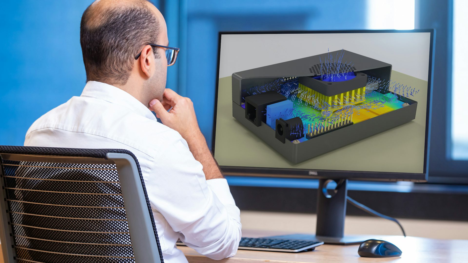 A man is looking at the Simcenter electronics cooling CFD and multiphysics software tool on a screen.