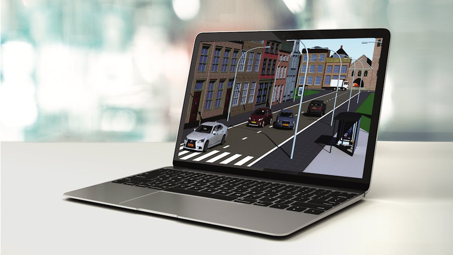 Laptop computer showing a simulation in Simcenter Prescan of an autonomous vehicle driving on a city street.