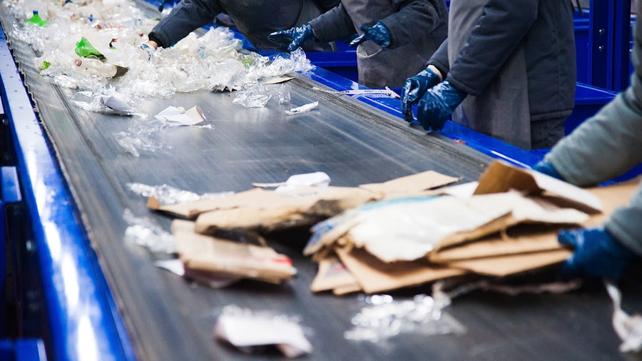 Production line in a waste recycling plant in operation with workers