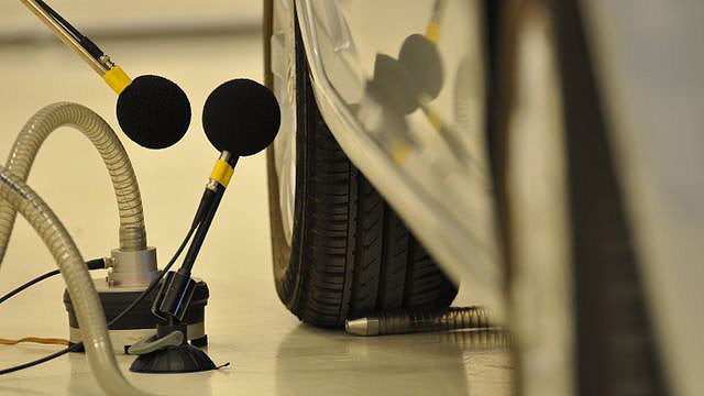 Equipment running a lowering pass-by noise level limits testing on a car.
