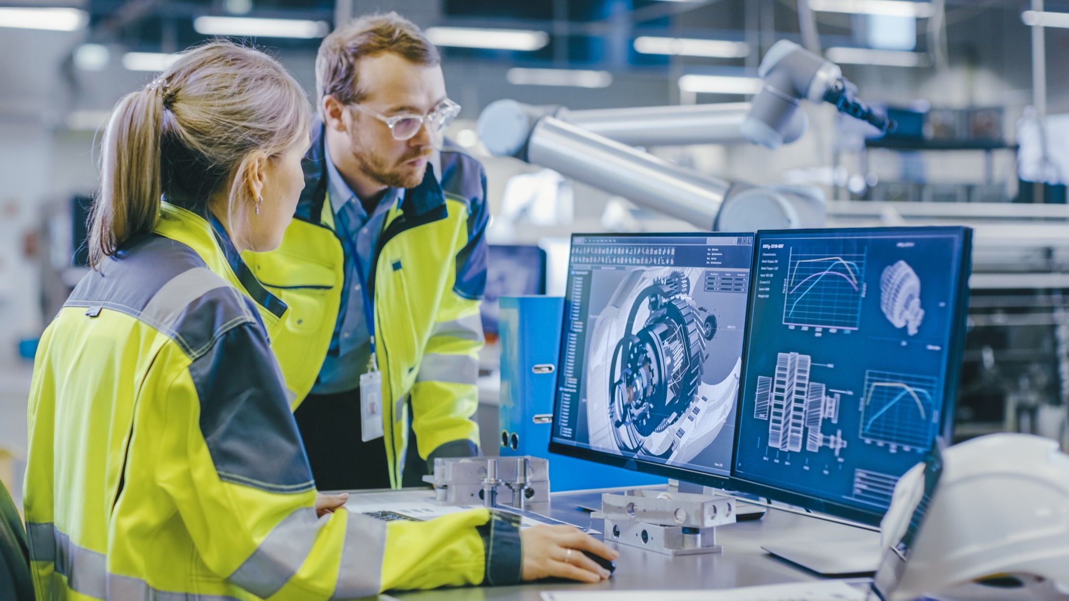 Engineers discuss 3D model of a mechanical design.