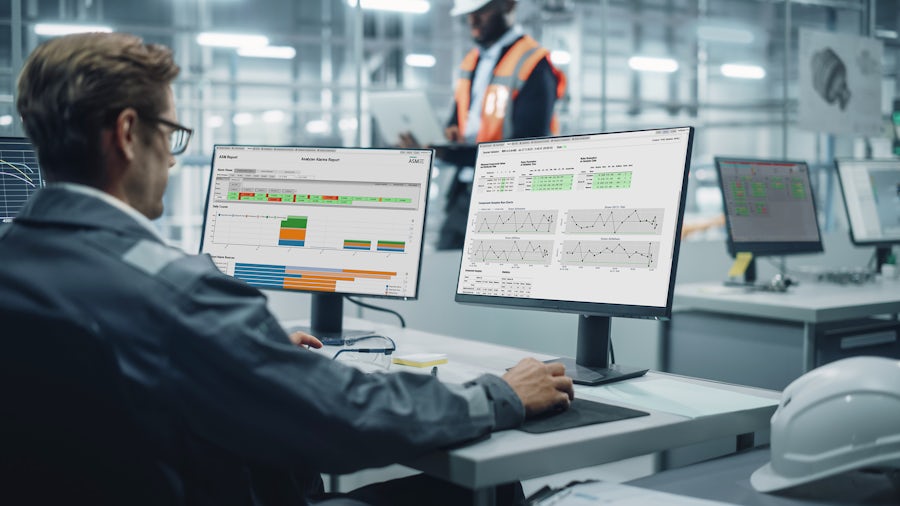 Vehicle Factory Line Operator Working at Desk, Overviewing Autonomous Electric Car Production in a Car Assembly Plant.