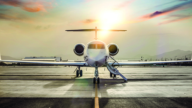 Una aeronave en una pista con el sol que ilumina desde detrás.