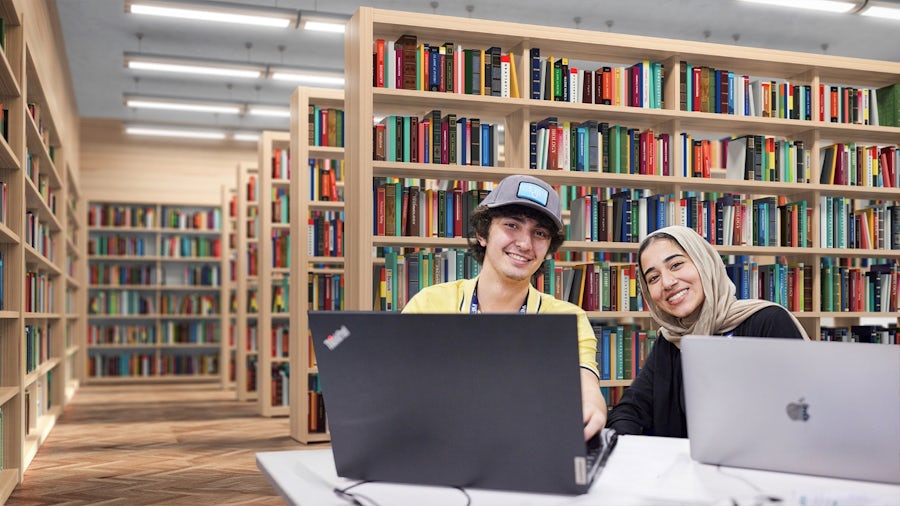 Two students sitting at a table in a library