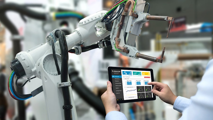 Un ingegnere ottimizza un robot industriale con un software di smart manufacturing da un tablet.