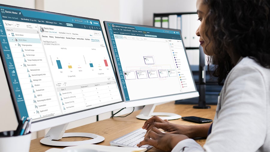 Woman sitting at a computer monitor working with Teamcenter Quality 2506 software.