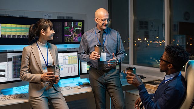Image of individuals in an Aprisa AI team meeting with the product displayed on monitors