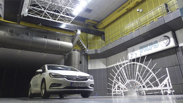 A vehicle in a Simcenter test center for wind tunnel testing.