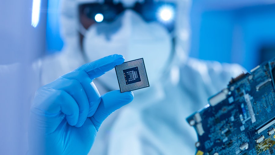 African-American scientist works in a modern scientific laboratory for the research and development of microelectronics and processors. Manufacturing worker uses computer technology and equipment.