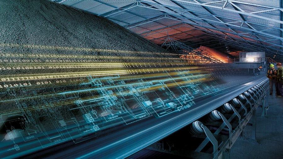 An image of mining conveyor belt digital twin going through a warehouse. With two people watching and analyzing it.