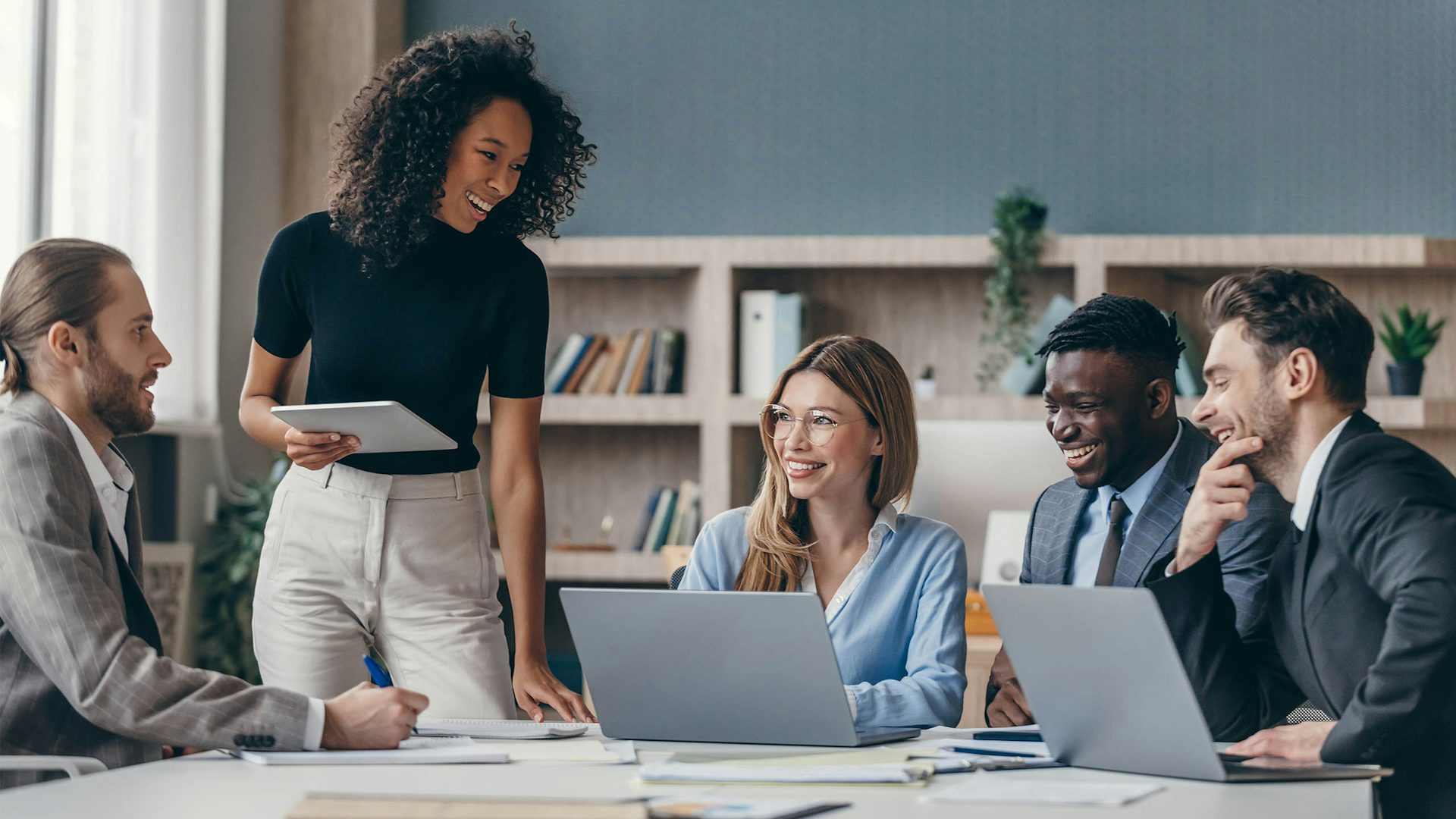 Group of business people sitting at a table having a meeting in an office.