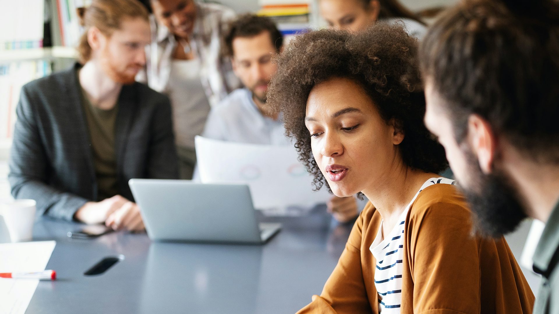 A group of business people sitting around a desk having a meeting. 