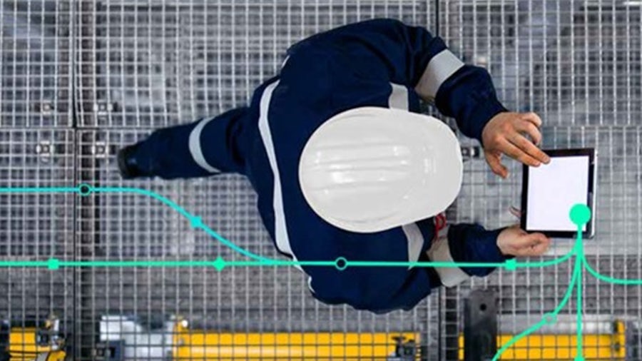 Worker in protective clothing on the move with a tablet and displayed data