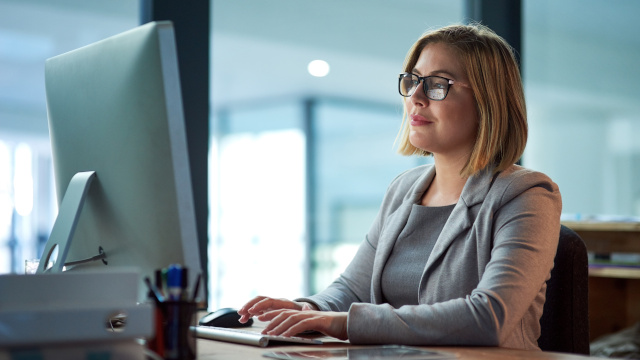Femme travaillant dans un bureau avec Teamcenter.