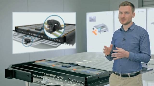 A manufacturing executive standing in front of the EDAG SCALEbat, a scalable battery housing for flexible electric vehicle platforms