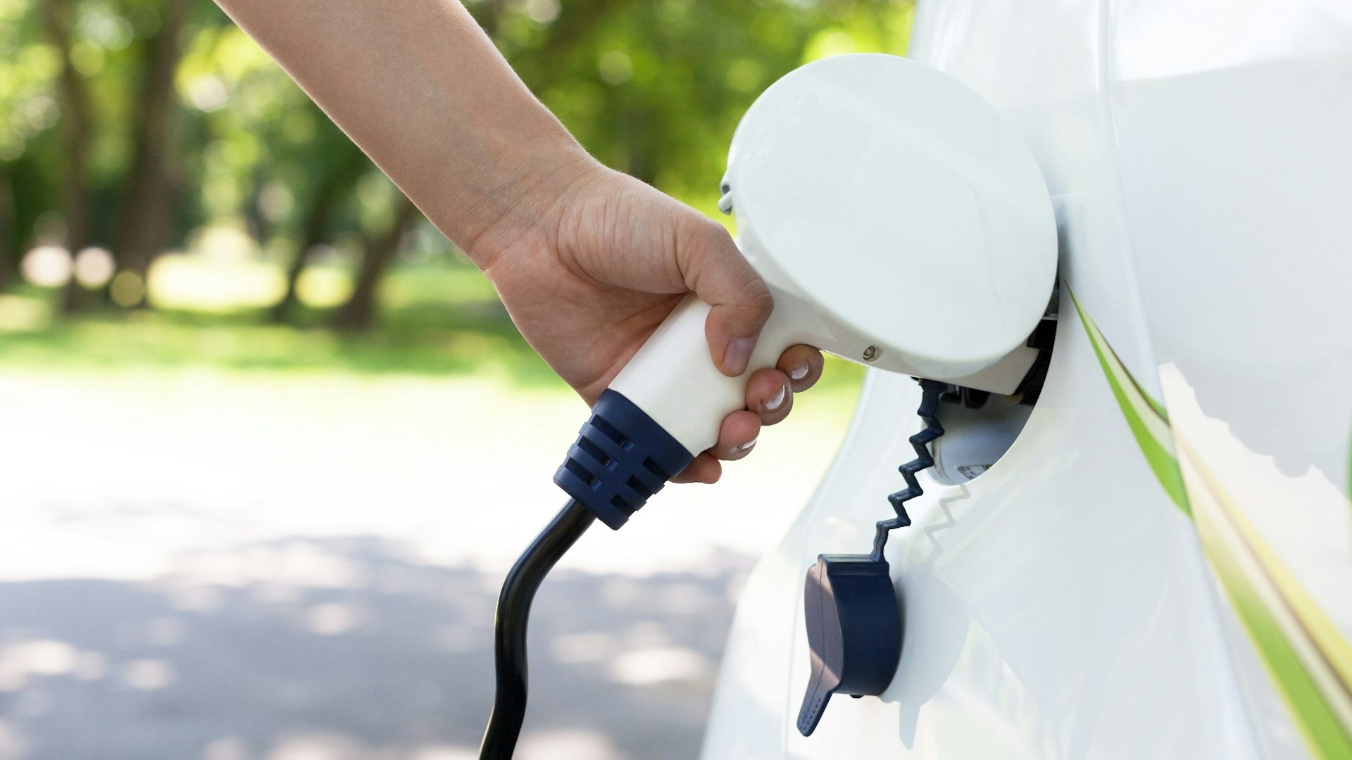 An electric charger being plugged into a car