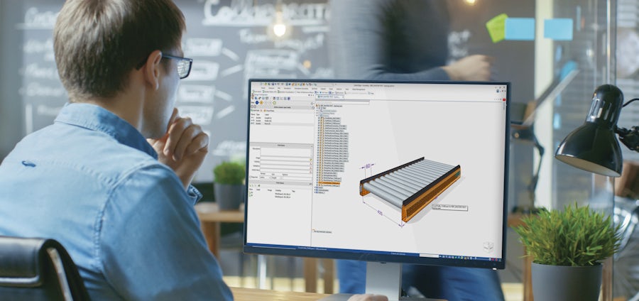 Male working at desktop workstation, customizing a rolling industrial assembly in Solid Edge Design Configurator