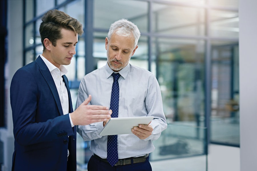 Two men having a discussion and looking at a tablet